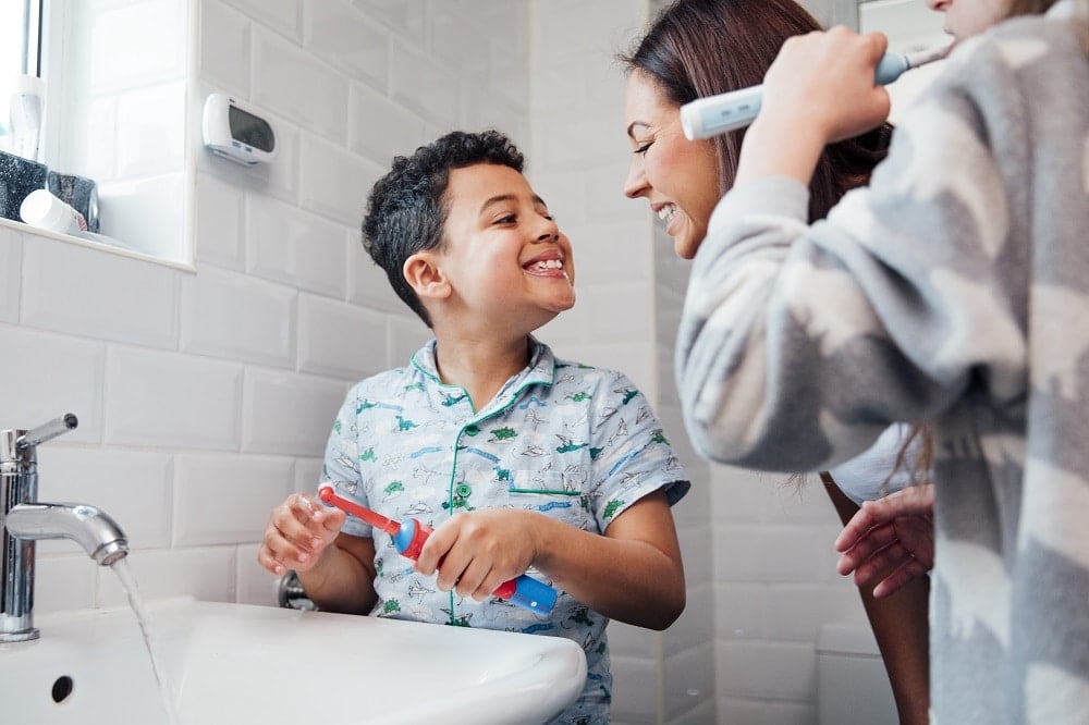 A child brushing their teeth with an electric toothbrush