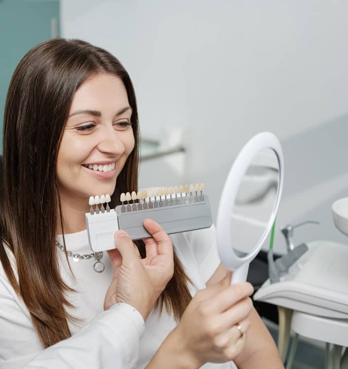 lady comparing the colour of teeth to veneers