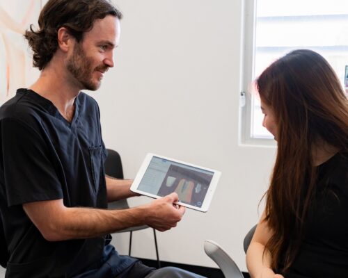 Dentist showing dental implant to patient