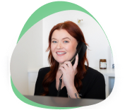 Smiling receptionist taking a phone call at the 123 Dental front desk