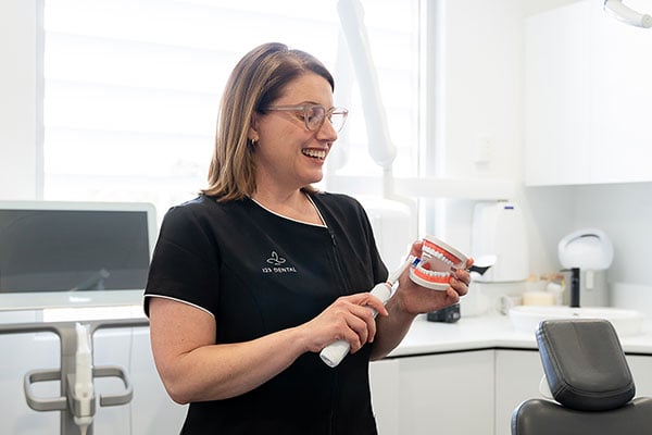 Dental assistant demonstrating preventive dental care