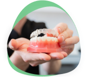 Close crop of hands cradling a full set of upper and lower dentures